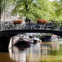 Bikes line the bridge over a canal in Amsterdam