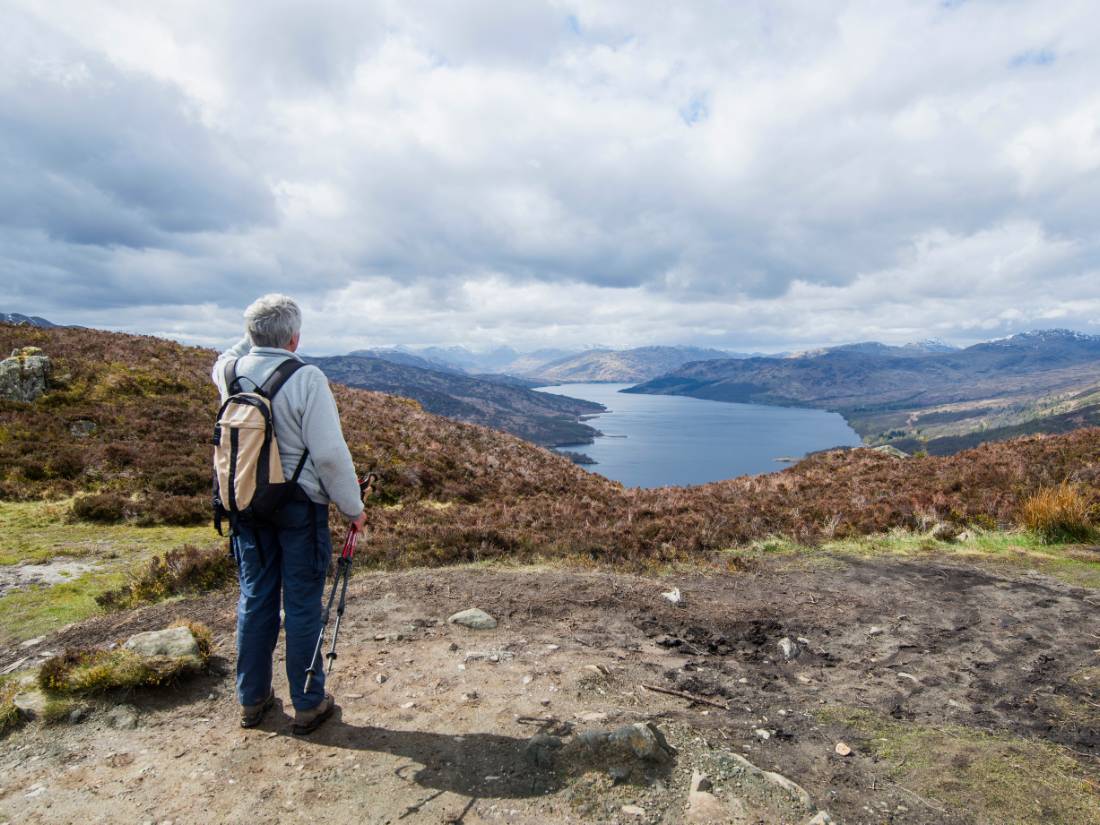 A walker admiring the view on the summit of Ben A an on the Rob Roy Way. |  <i>Kenny Lam</i>