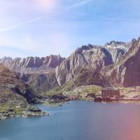 The historic Great St Bernard Pass refuge nestled between a lake and soaring mountains on the Via Francigena in Switzerland | Stephane Engler