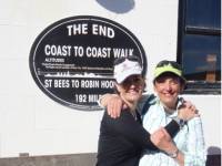 Happy hikers at the end of the Coast to Coast Trail in Robin Hood's Bay |  John Millen